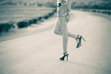beautiful woman legs in high heel shoes on the roadの写真素材