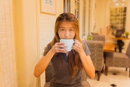 Asia beautiful woman drinking coffee in cafeの写真素材