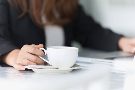 Asia young business woman sitting in cafe with laptop and hot coffee, business conceptの写真素材