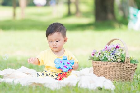 Asia Baby boy on green grass in the park , Chiangrai Thailandの写真素材