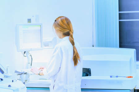 young beautiful woman scientist working with a device for blood analysis