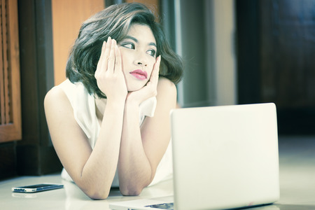 Asia office woman lying on floor with open laptop at homeの写真素材