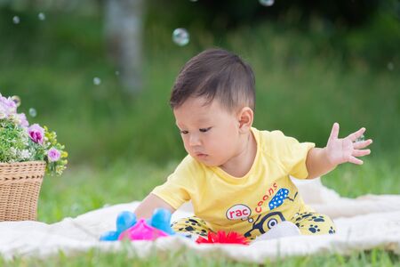 Asia Baby boy on green grass in the park , Chiangrai Thailandの写真素材