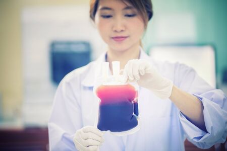 Bag of Blood in hand asian woman Doctorの写真素材