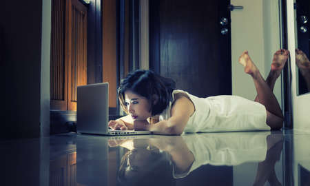 Asia office woman lying on floor with open laptop at home, vintage effectの写真素材