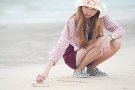 Heart on the beach hand asia woman is writing