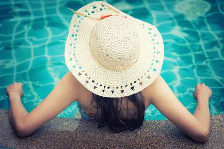Asia pretty woman in hat enjoying swimming poolの写真素材