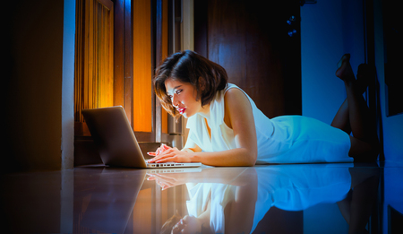 Asia office woman lying on floor with open laptop at home, vintage effectの写真素材