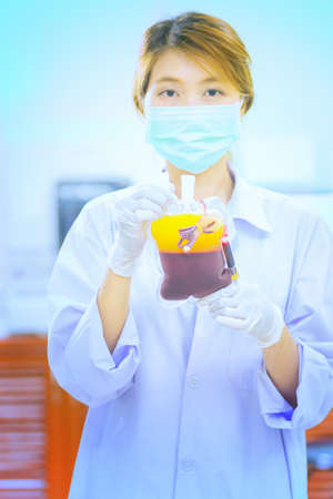 Bag of Blood in hand asian woman Doctorの写真素材
