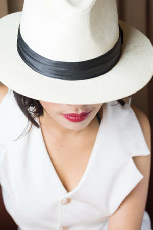 Portrait of beautiful young woman with white hatの写真素材