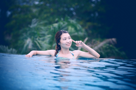 Asia young beautiful woman portrait in swimming poolの写真素材