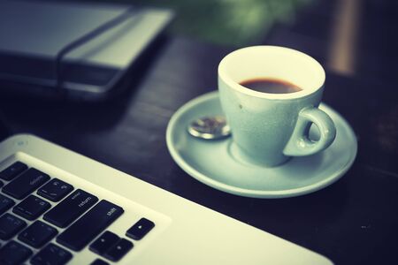 working time. hot coffee, espesso with laptop on wood teble. business conceptの写真素材