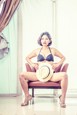 asia beautiful women in bikini sitting on chair at the room, vintage effectの写真素材