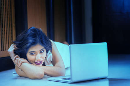 Asia office woman lying on floor with open laptop at home, vintage effectの写真素材