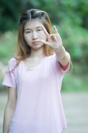 asia beautiful young woman show one hand love signの写真素材