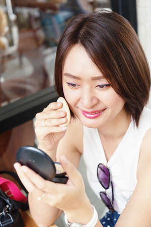 make up woman holding powder puff