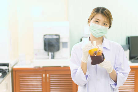 Bag of Blood in hand asian woman Doctorの写真素材