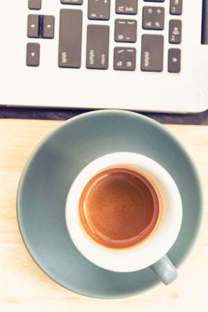 working time. hot coffee, espesso with laptop on wood teble. business conceptの写真素材