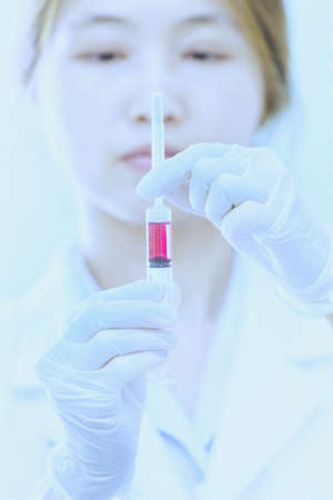 Doctor with red vaccine syringe in handの写真素材