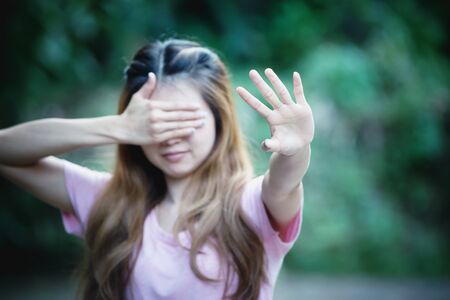 asia woman covers her face with her hand and shows stopの写真素材