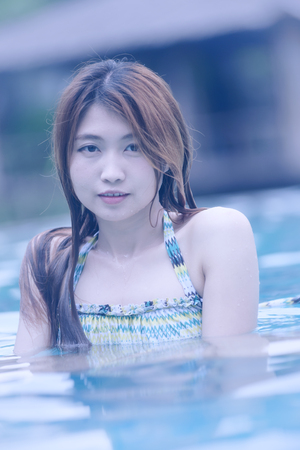 Asia young beautiful woman portrait in swimming poolの写真素材