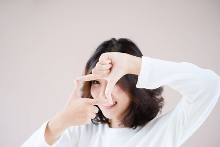 asia beutiful girl make hand symbol the frameの写真素材