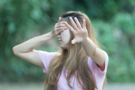 asia woman covers her face with her hand and shows stopの写真素材
