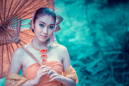 ancient Thai Woman In Traditional dress Of Thailand with vintage umbrellaの写真素材