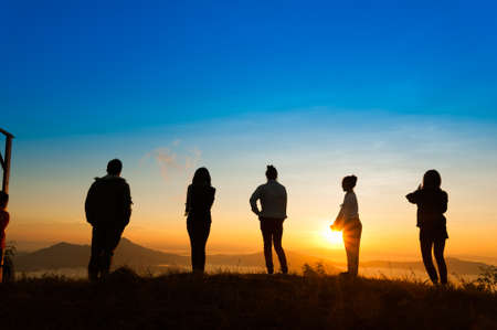 Landscape view of sunrise on misty  mountain hills with women and man silhouette, phatang mountain Chiangrai Thailandの写真素材