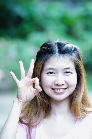 asia young cute woman showing "OK"の写真素材