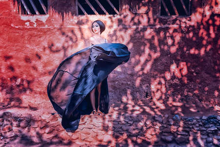 High fashion shot of asia elegant woman in fluttering black long dress