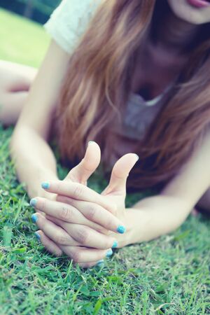 asia woman lying with Thumbs up sign against grass in park, vintage effectの写真素材