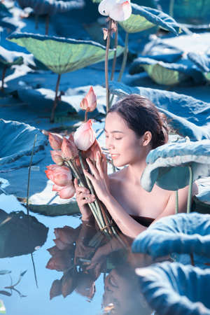 amezing of beautiful young woman Farmer  collecting lotus in garden. thai lifestyle  people in local,Thailandの写真素材