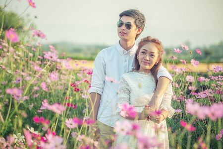 Couple playing in the garden flowers. Both happy and smiling on Valentine's Dayの写真素材