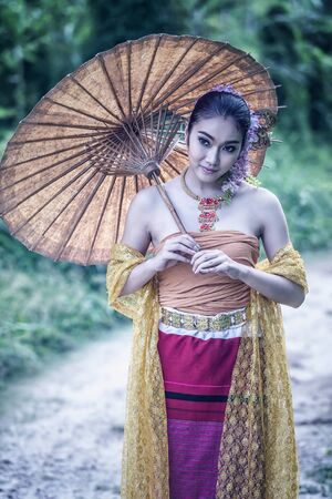 ancient Thai Woman In Traditional dress Of Thailand with vintage umbrella, vintage effectの写真素材