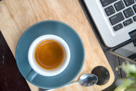 working time. hot coffee, espesso with laptop on wood teble. business conceptの写真素材
