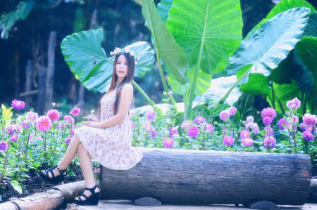 portrait of asia young women sitting in colorful flower gardenの写真素材