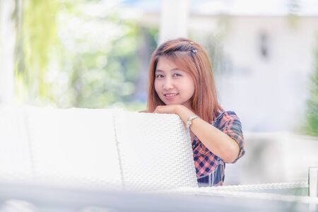 portrait of Asia beautiful girl sitting on white chairの写真素材