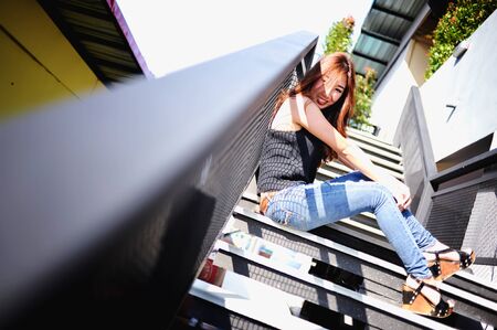 asia beautiful fashion model woman sit on ladderの写真素材