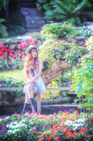 portrait of asia young women sitting in colorful flower gardenの写真素材