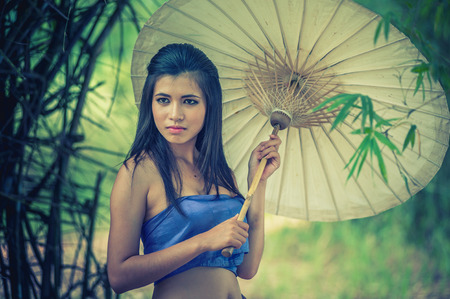 ancient Thai Woman In Traditional Costume Of Thailand with vintage umbrella, vintage effectの写真素材