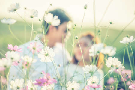 Couple playing in the garden flowers. Both happy and smiling on Valentine's Day, flower focusの写真素材