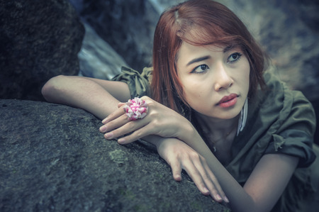 Portrait of Asia Beautiful young girl stand at water fall, cross process effect for vintage styleの写真素材