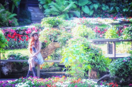portrait of asia young women sitting in colorful flower gardenの写真素材