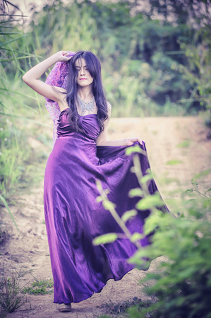 asia Pretty girl walking on nature in purple dressの写真素材