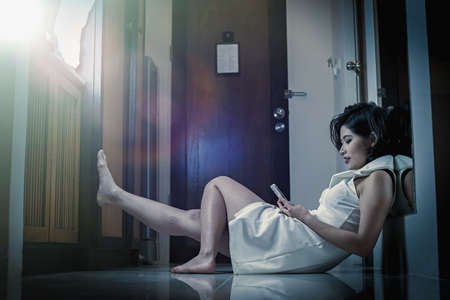 asia Pretty girl sitting on floor using smart phone in the room, add flare, vintage style