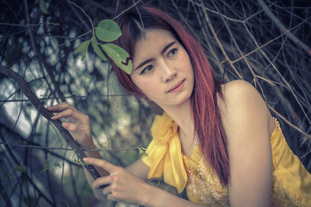 Portrait of Asia Beautiful woman in yellow dress on natureの写真素材