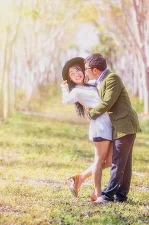 asai young romantic man and woman standing and hugging each other with tenderness in the field. Young love concept.の写真素材