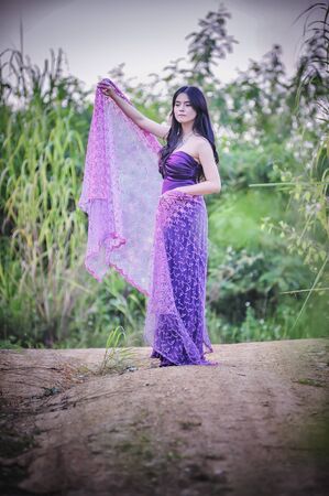 asia Pretty girl walking on nature in purple dressの写真素材