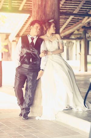 couple in love. portrait of asia young stylish fashion couple posing on outdoor. wedding style, love concept, add flare and vintage effectの写真素材